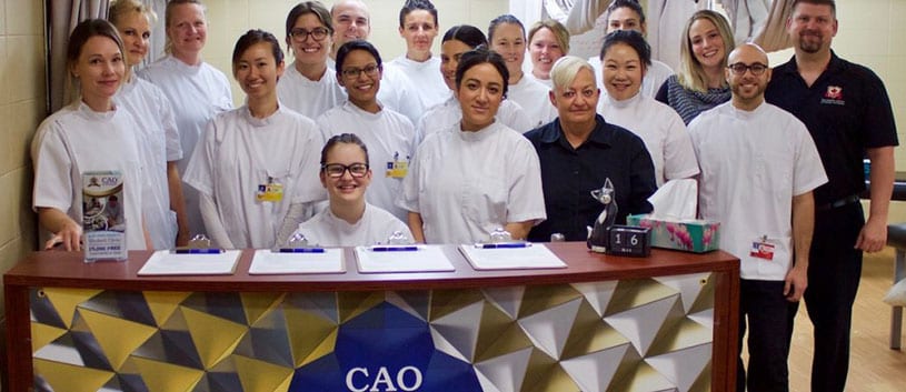 Students of the CAO standing at the student clinic celebrating 30,000 free treatments