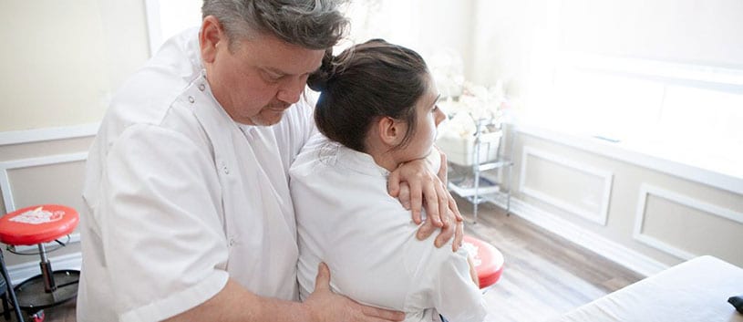 Principal Robert Johnston performing osteopathic therapy on a student at the CAO clinic